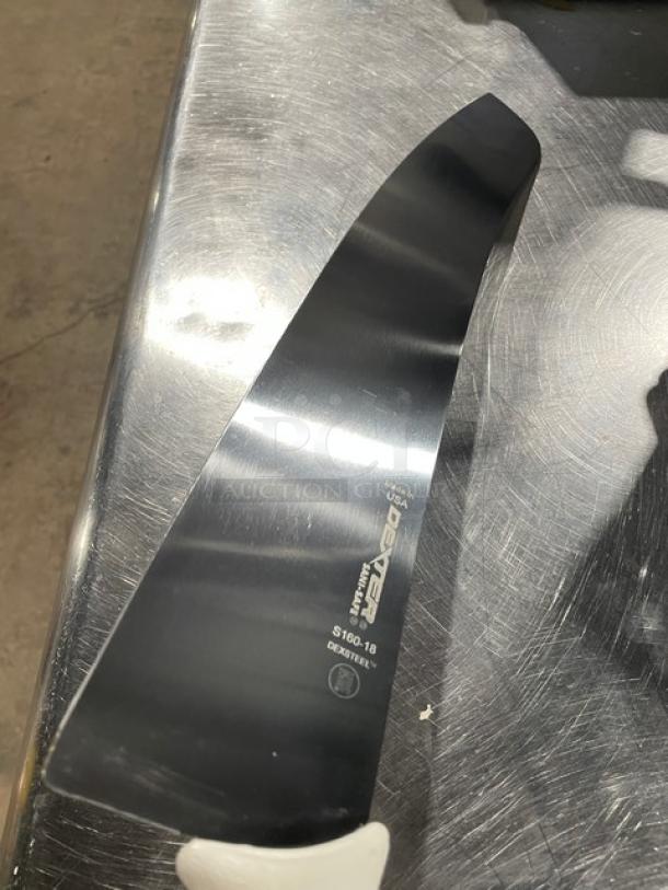 Dexter S16018 18" carbon steel pizza knife, new in box, shown on a metal surface. Blade engraved with brand and model.