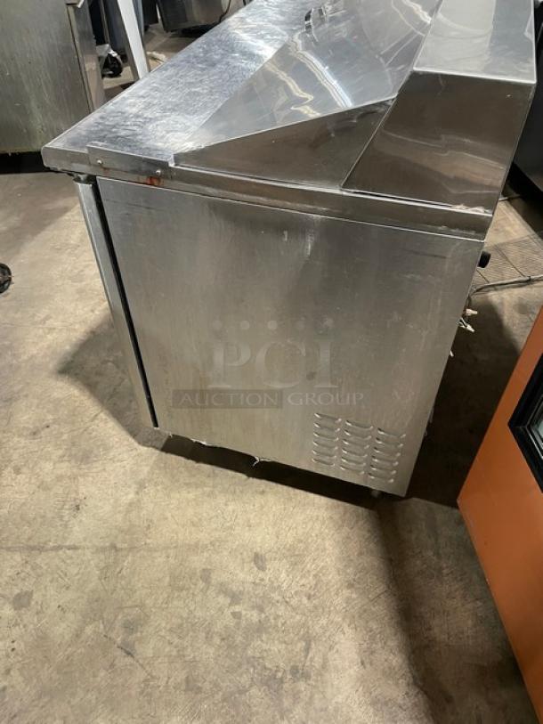 Turbo Air TST60SD stainless steel refrigerated prep table with two-door storage and caster wheels.