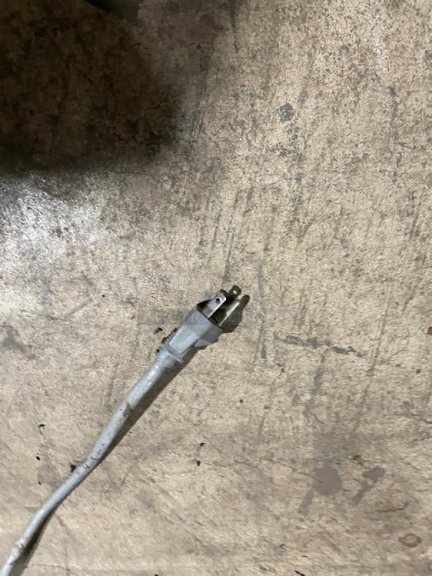 Close-up of an electrical plug on the ground, related to Turbo Air Refrigerated Sandwich/Salad Prep Table Model TST60SD.