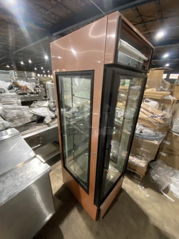 True commercial electric refrigerated bakery display, model G4SM23RGS. Features rotating glass shelves, one shelf broken, SN: 5166615.