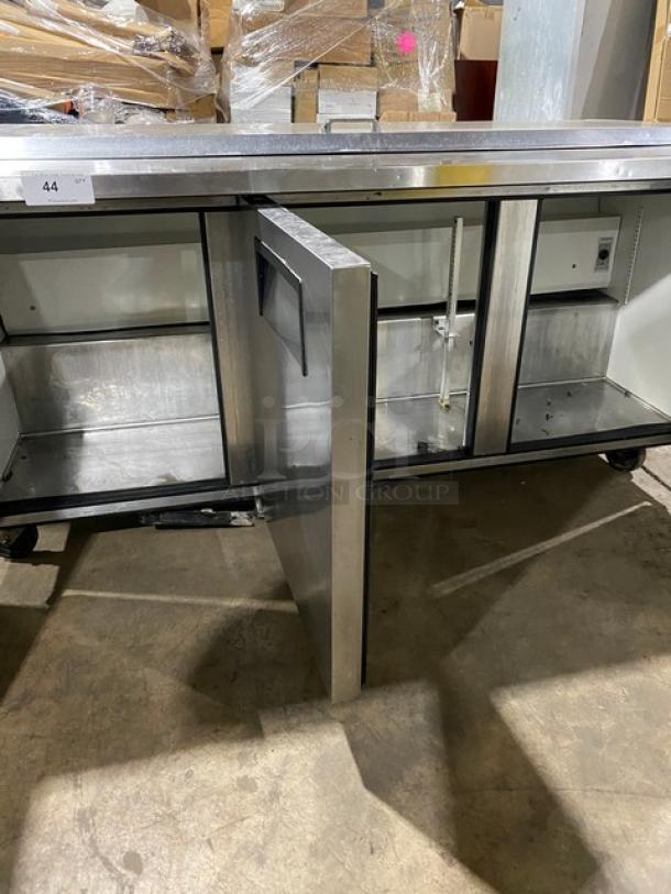 True commercial refrigerated pizza prep table, model QA7230MB, with three-door storage, stainless steel, 115V. Model and serial labels are visible.