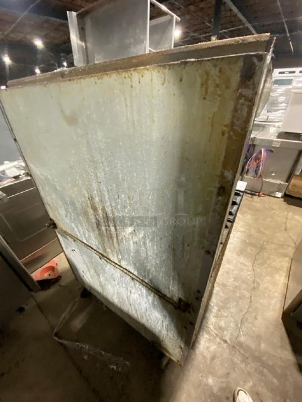 Imperial stainless steel 6-burner gas stove with overhead salamander and full-size oven. Visible wear on the surface.