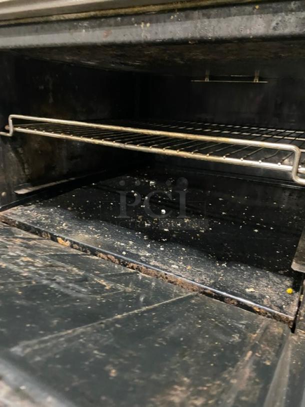 Imperial stainless steel 6-burner commercial gas stove with overhead salamander shelf and full-size oven, showing detailed interior.