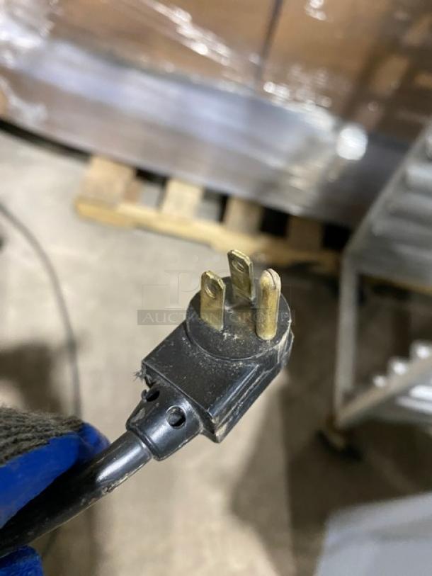 Close-up of a three-pin power plug for a True refrigerated work/prep table, model TWT60, indicating 115V power.