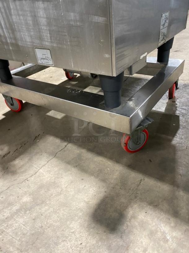 Rational commercial combi oven base; stainless steel, durable caster wheels, minor wear; ideal for professional kitchens.