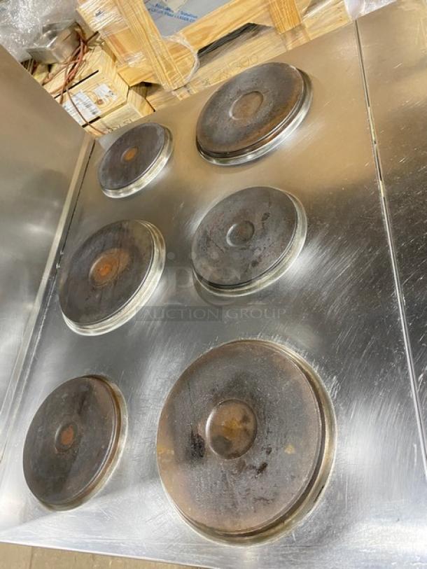 Cookline commercial 6 burner induction range with stainless steel finish, raised backsplash, salamander shelf, and oven. 208V.