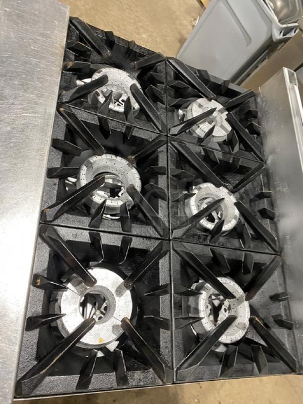 Vulcan commercial 6-burner natural gas stove with stainless steel finish, full-size oven, and casters for mobility.