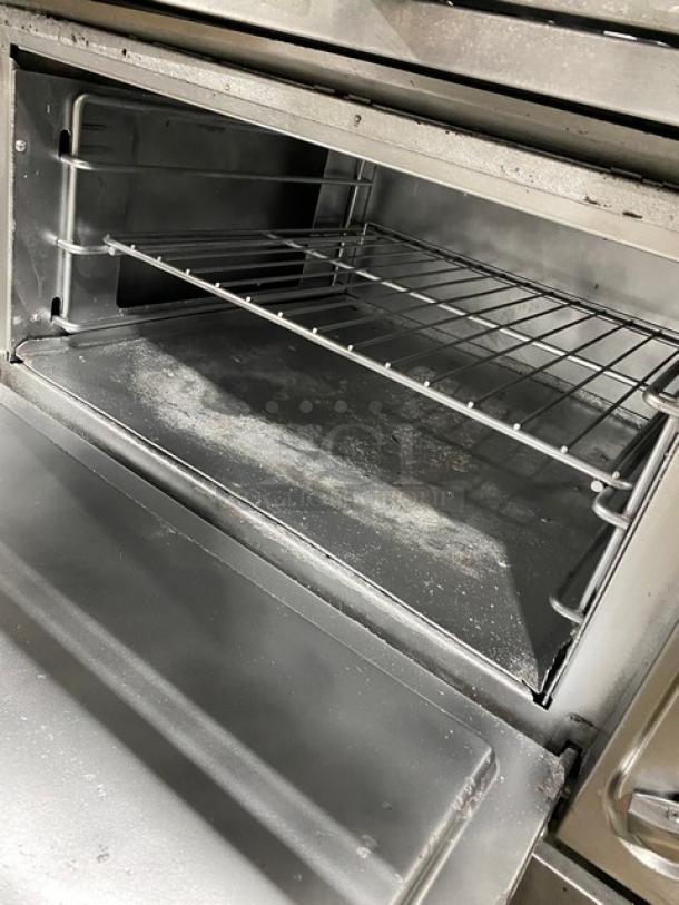 Vulcan commercial stove with 6 burners, full-size oven, stainless steel construction, and casters; natural gas powered.