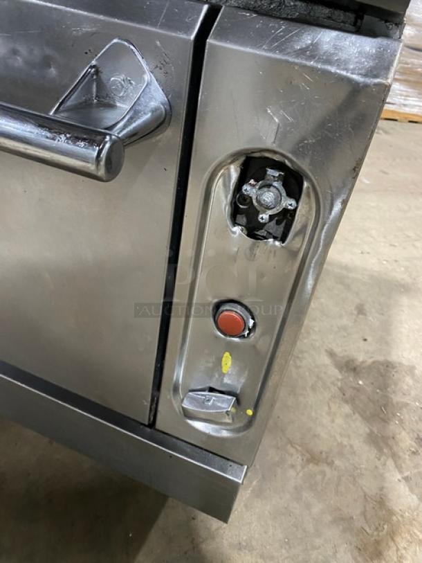 Vulcan stainless steel 6 burner stove with full-size oven, natural gas-powered, on casters, shows control panel and handle.