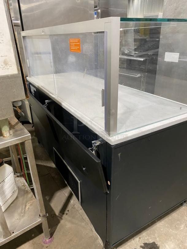 Structural Concepts refrigerated merchandiser display case with enclosed-glass showcase, rear sliding doors, and prep shelf.