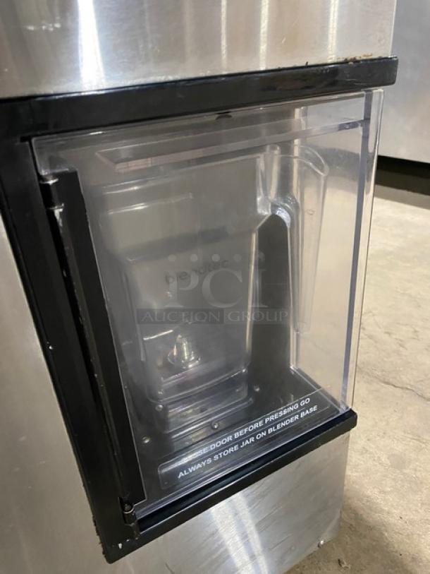 Blendtec commercial blender with ice dispenser, stainless steel, digital controls; features visible jar and markings. 120V.