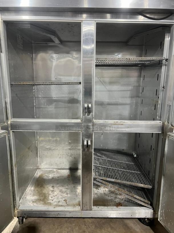 True commercial refrigerator, model STG2R4HS, with four stainless steel half doors, on casters, showing interior shelving.