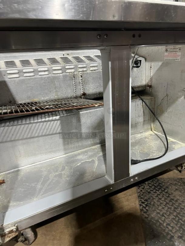 Continental refrigerated sandwich prep table, model SW4818M. Features stainless steel, 2-door storage, cutting board. Visible interior wear.