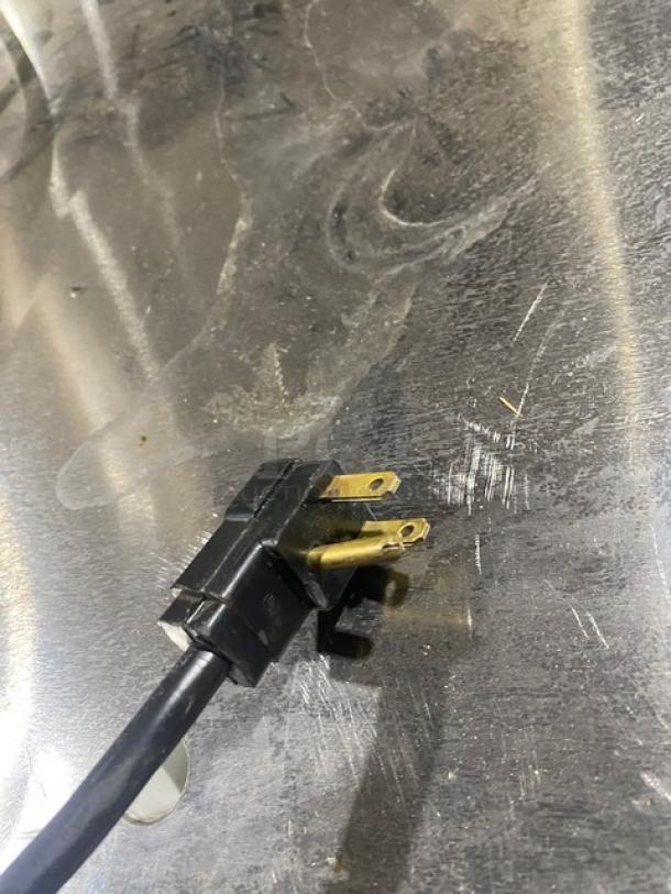 Beverage-Air kegerator plug on stainless steel worktop, showing black cord and prongs. Model: DD36HC-1-B.