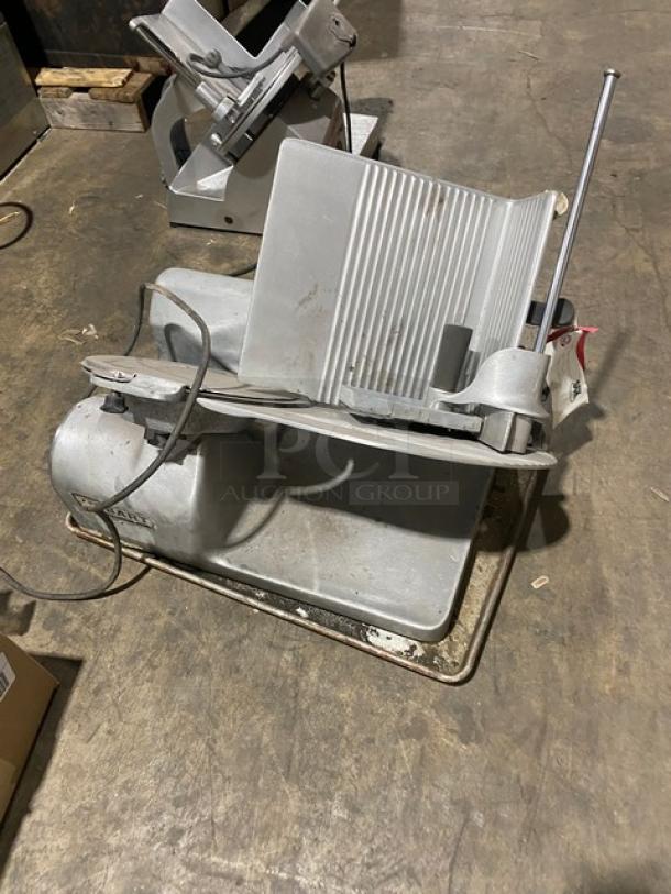 Hobart 1612 Commercial Meat Slicer, electric powered, on legs. Visible wear, with power cord and control lever.