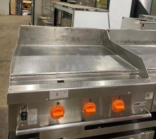 Woodstone 36" flat griddle, model WSGPL3636CT01NG, stainless steel, natural gas, with back and side splashes, on legs.