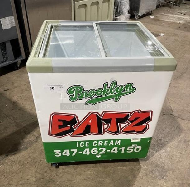 Commercial chest freezer merchandiser with sliding glass doors, branded "Brooklyn Eatz Ice Cream." Features 110V power, good condition.