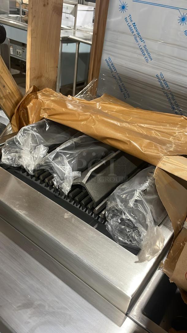 Brand new Jade Range JURH-CHP Trio Combo Unit in crate; features a 24" charbroil grill, 24" flat plancha, 2-drawer refrigerated chef base, stainless steel backsplash, on casters.