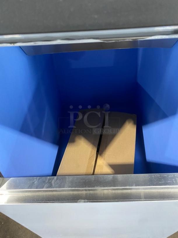 Interior view of a brand new Scotsman Model NS0422A-1B ice bin, blue interior, showing empty space with a cardboard placeholder.