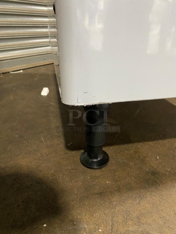 Scotsman ice machine leg, black plastic, attached to a white exterior. Model NS0422A-1B, new condition.