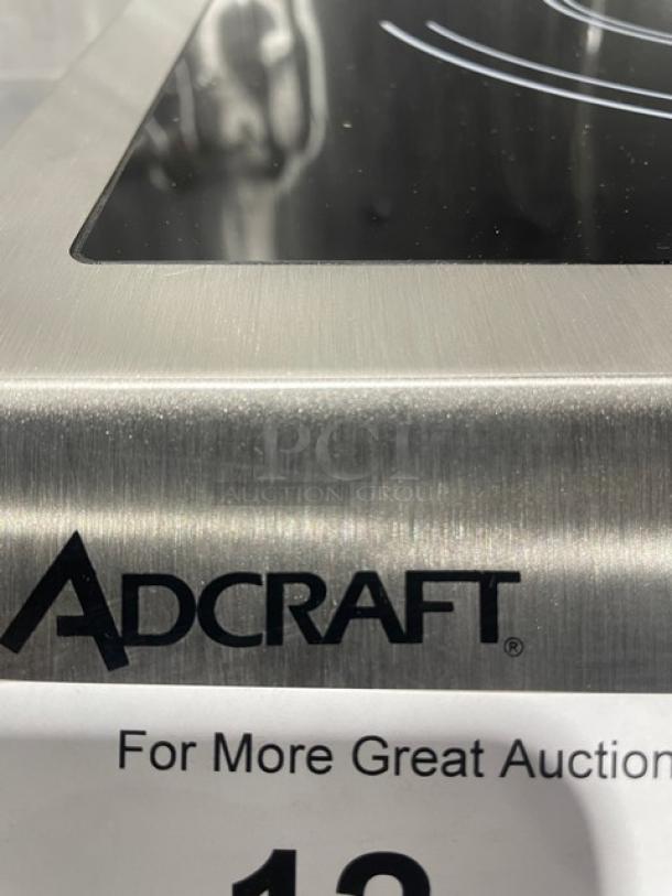 Adcraft INDB120V induction cooker, stainless steel body, new condition, 2015 model, serial 12150270, visible branding.