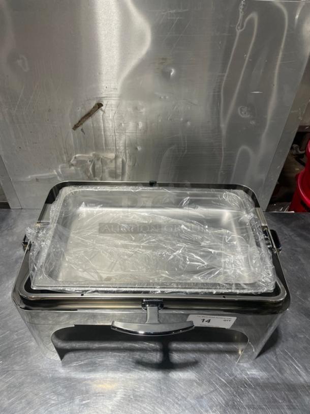 Stainless steel buffet chafing dish with handles and drop-in pan, new condition, partially wrapped in plastic.