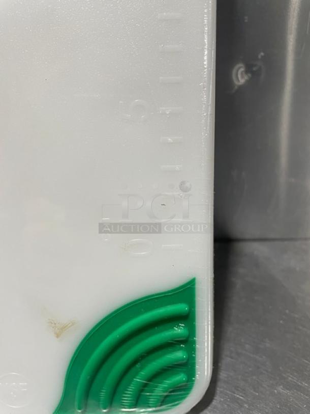 Brand new San Jamar Saf-T-Grip cutting board, white with green corner grip, visible measurements. Durable and non-slip.