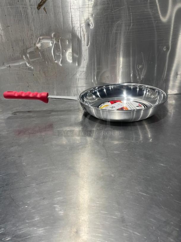 Adcraft Aluminum Frying Pan, Model HER-12FP/4, with red rubber grip handle, new condition, reflective metal surface.