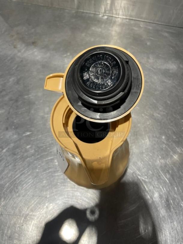 Service Ideas insulated ABS plastic coffee carafe with push button lid, new condition, beige color, ideal for hot beverages.