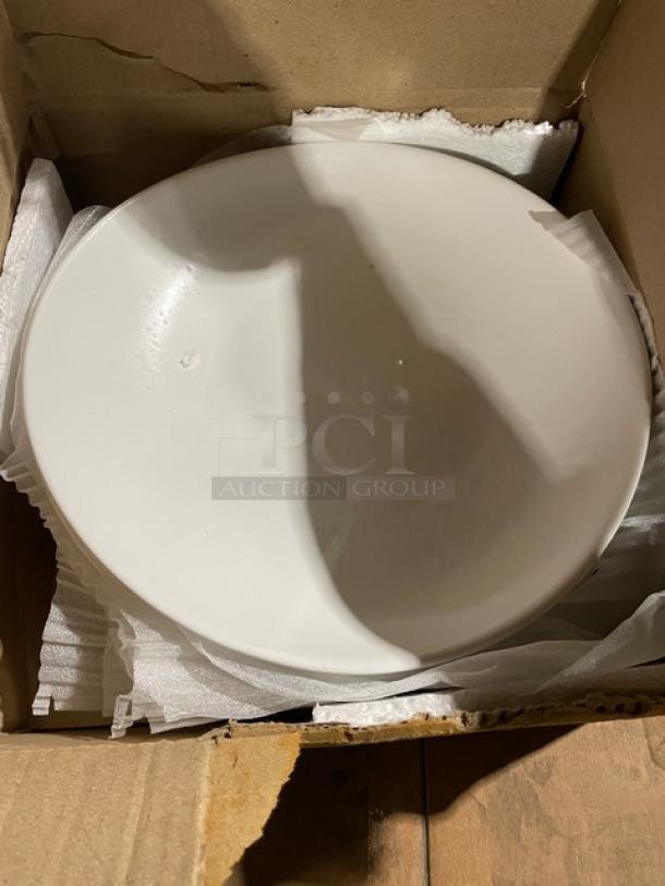 Cardboard box containing a white ceramic bowl, cushioned with packing material. Item is in brand new condition.