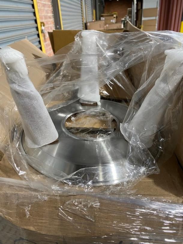 Mixed pallet of commercial kitchenware, including stainless steel components wrapped in plastic for protection.