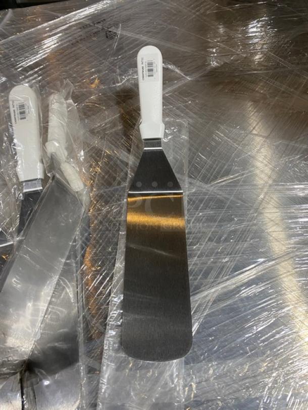 Brand new Crestware PHT103 stainless steel 10" solid turner with white grip handle, showing retail tags.