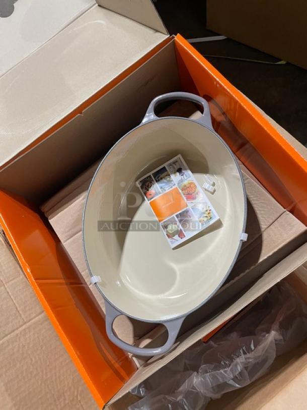 Brand new Le Creuset 6.75 Qt. oval Dutch oven, oyster enameled cast iron, in box with handles and stainless steel knob lid.