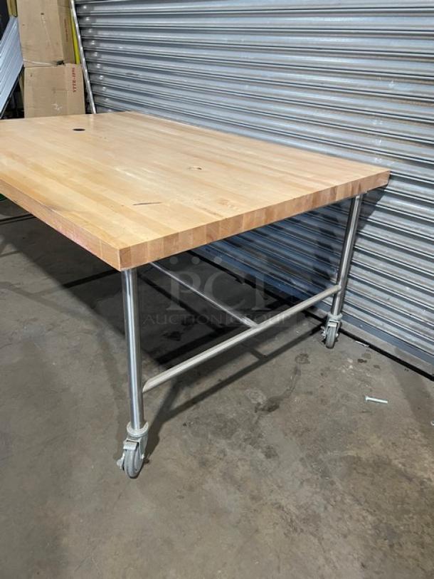 Lightly used commercial 72"x48" wooden butcher-block worktop table on casters, features sturdy metal legs, excellent condition.