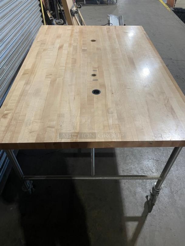 Lightly used wooden butcher-block style worktop, 72"x48", on metal casters. Features three circular openings.