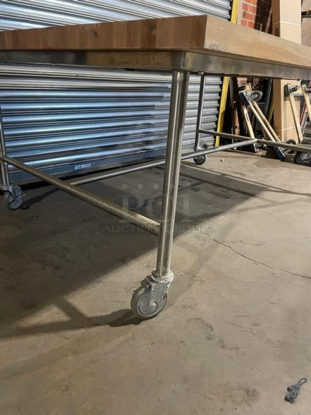 Lightly used 72"x48" commercial wooden butcher-block worktop on casters. Sturdy metal frame, ideal for prep work.