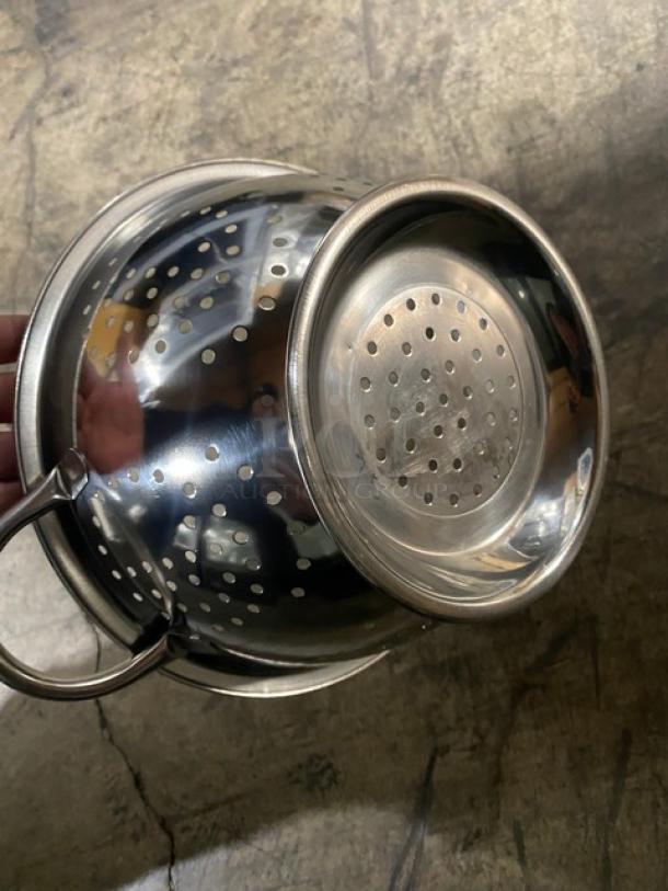 "Brand new ABC commercial stainless steel perforated colander with handles. Shiny, reflective, ideal for kitchen use."