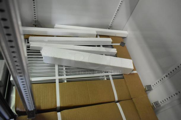 Brand new True GDM-33-HC-LD cooler merchandiser interior showing packaged poly-coated racks and protective materials.