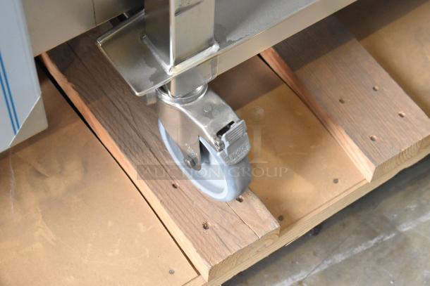 Caster wheel of a new Henny Penny FPGM22172007 stainless steel combi convection oven, resting on a wooden pallet.