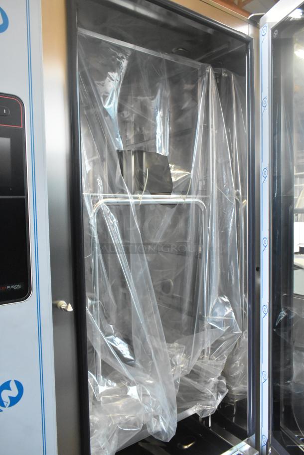 Brand new scratch and dent 2023 Henny Penny stainless steel combi convection oven, model FPGM22172007, with pan rack.