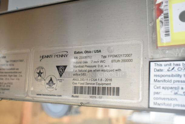 Label on Henny Penny FPGM22172007 stainless steel oven; details gas type, pressure, and BTU. ANSI and CSA certified.
