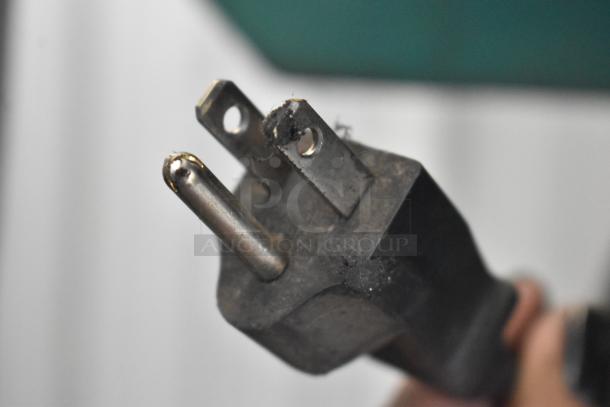 Close-up of a power plug from a Champion VR10-12 air compressor, showing signs of wear, suitable for 460 volts, 3 phase.