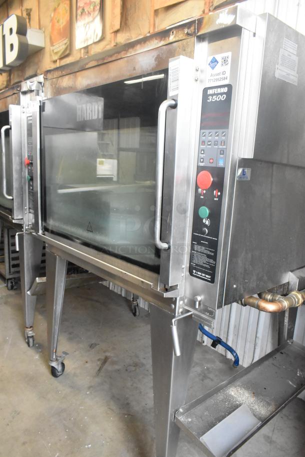 Hardt Inferno 4500 stainless steel rotisserie oven, natural gas, commercial casters, skewers, control panel visible.