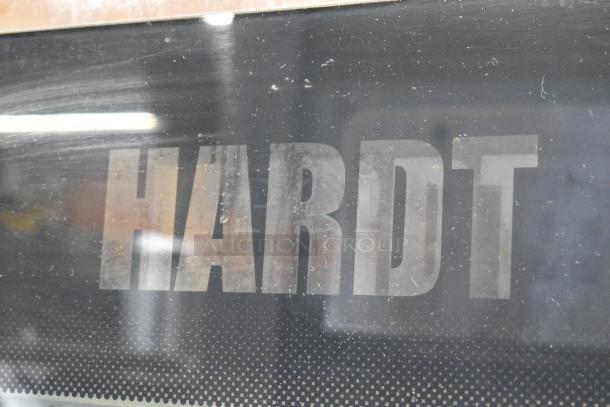 Hardt Inferno 4500 stainless steel rotisserie oven, natural gas powered, includes skewers, metal legs, commercial casters.