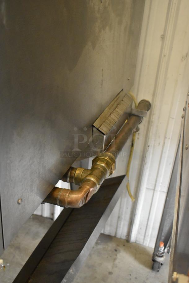 Hardt Inferno 4500 stainless steel commercial rotisserie oven, natural gas powered, shown with metal piping and commercial casters.