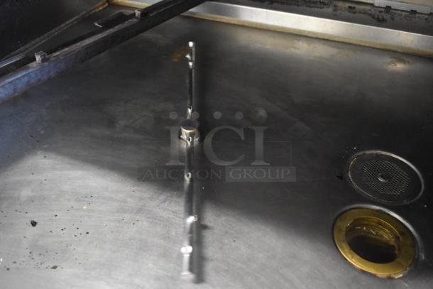 Hardt Inferno 4500 stainless steel rotisserie oven, natural gas-powered, with skewers, metal legs, and commercial casters.