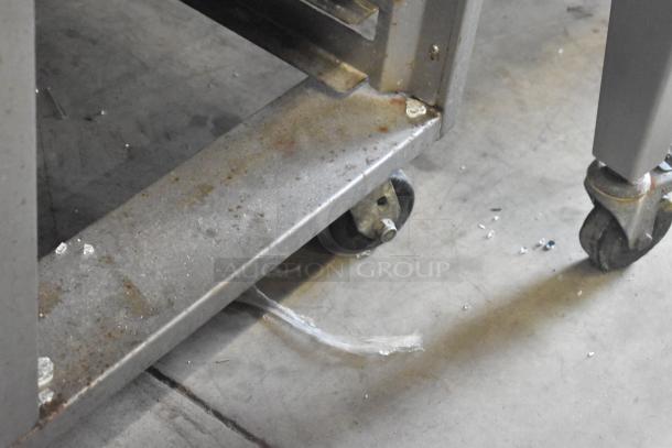 Baxter OV310G stainless steel oven base, showing commercial casters on a concrete floor. Right side door stuck.