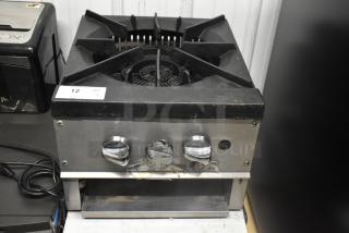 Stainless steel commercial countertop gas burner with three control knobs, number tag 12, slight wear visible.