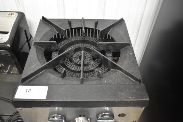 Stainless steel commercial countertop gas-powered single burner stock pot range with a robust cast-iron grate.