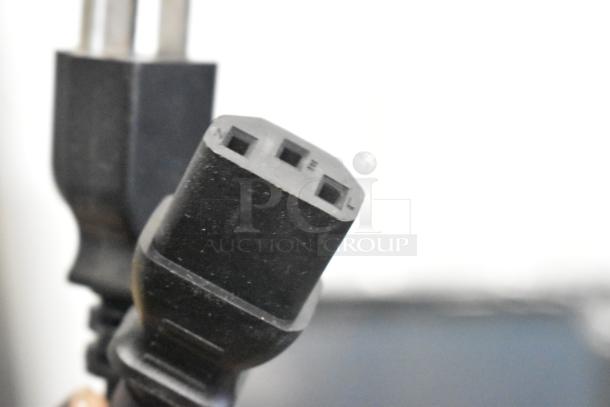 Close-up of a black power plug for the Hobart HTi-SSLSC scale, showing prongs and connection ports.